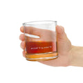 Hand holding a glass with 'Iron Heritage' branding on a white background