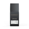 Black coffee packaging with 'The Modern Den' branding on a white background